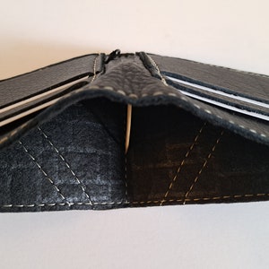Schwarze Ledergeldbörse mit 4 Kartenfächern und innen gefüttertem Innenraum für Bargeld. Weich. Schlank. Handgefertigt. Minimal. Einzigartig.