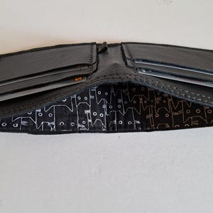 Schwarze Ledergeldbörse mit 4 Kartenfächern und innen gefüttertem Innenraum für Bargeld. Weich. Schlank. Handgefertigt. Minimal. Einzigartig.