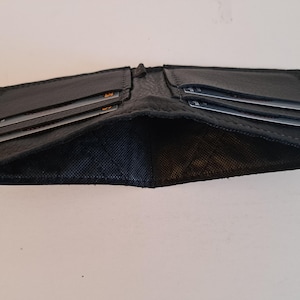 Schwarze Ledergeldbörse mit 4 Kartenfächern und innen gefüttertem Innenraum für Bargeld. Weich. Schlank. Handgefertigt. Minimal. Einzigartig.