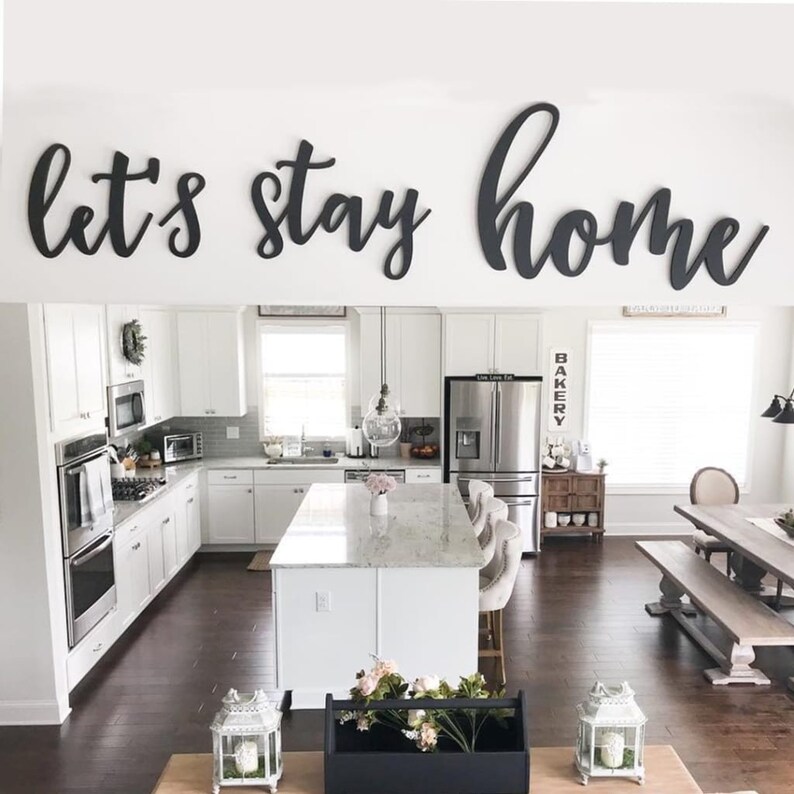painted wood letter sign saying let's stay home