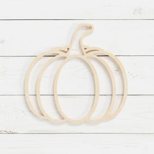 May include: A wooden cutout of a pumpkin with a simple design. The pumpkin is outlined with a single line and has a stem.