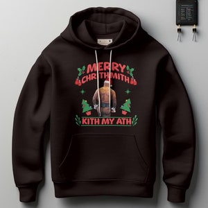 May include: Black hooded sweatshirt with a Christmas-themed design featuring a man wearing a Santa hat and the text "Merry Chrthmith Kith My Ath".