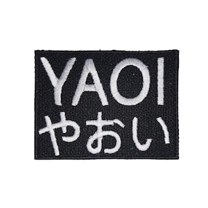 May include: Black embroidered patch with the word "YAOI" and the Japanese characters for "yaoi" in white.