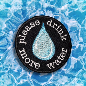 May include: Black and white embroidered patch with a blue water drop and the text "Please drink more water".