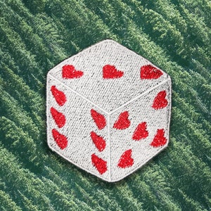 May include: White fabric dice with red embroidered hearts on each side.