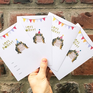 May include: Four white invitation cards with a colourful banner and a cartoon frog wearing a party hat. The text on the cards reads "Let's Party!"
