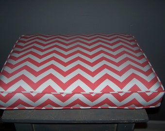 Puede incluir: Un cojín con estampado de chevron rojo y blanco para un banco o una silla.