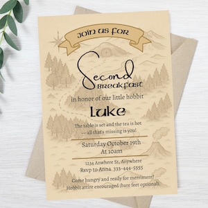 以下が含まれることがあります： 地図のデザインが施されたベージュ色の招待状で、「Second Breakfast」イベントを発表しています。カードにはテキスト、「Join us for」と書かれたバナー、そして「Luke」という名前が含まれています。招待状は薄茶色の封筒に入っています。