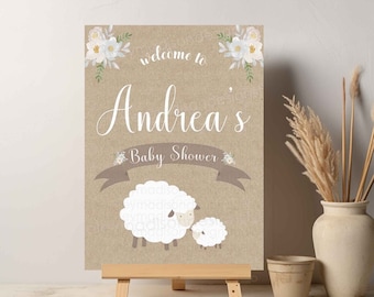 May include: Welcome to Andrea's Baby Shower sign with a brown background, white flowers, and two white sheep.