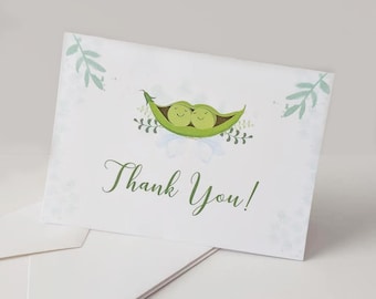 May include: A set of thank you cards with a green peapod design. The peapods have two peas inside with smiling faces. The text "Thank You!" is written in green cursive.