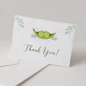 May include: A set of thank you cards with a green peapod design. The peapods have two peas inside with smiling faces. The text "Thank You!" is written in green cursive.