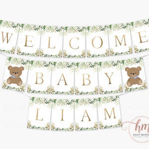 May include: Welcome Baby Liam banner with a green and gold leafy design. The banner has two brown teddy bears with blue bows.