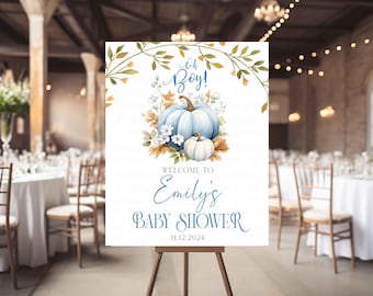 May include: A baby shower sign on an easel. The sign features a watercolor design with blue pumpkins, flowers, and the text "Oh Boy!" and "Welcome to Emily's Baby Shower 11.12.2024". The sign is set up in a decorated event space.