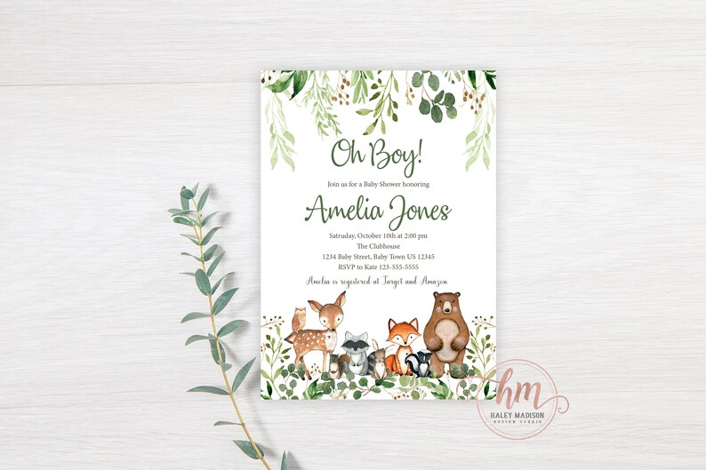 May include: A baby shower invitation with a woodland theme. The invitation features a watercolor illustration of a deer, fox, raccoon, owl, and bear surrounded by green foliage. The text on the invitation reads "Oh Boy!" and "Amelia Jones".