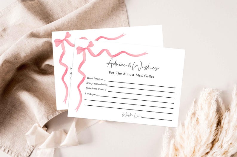 May include: A white card with pink ribbon designs and the text "Advice & Wishes for The Almost Mrs. Gelles". The card has lines for writing advice and wishes.