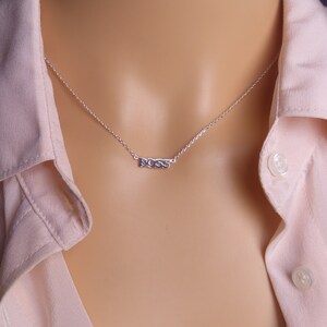 May include: A silver necklace with the word "BOSS" spelled out on a pendant.