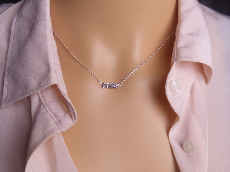 May include: A silver necklace with the word "BOSS" spelled out on a pendant.