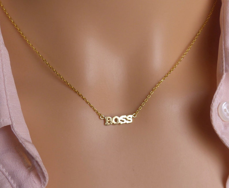 May include: A gold chain necklace with a pendant that says "BOSS" in block letters.