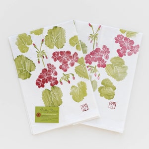 May include: Two white flour sack dish towels with a green and pink floral print. The towels feature the text "Pretty Flowers" and "Flour Sack Dish Towel".
