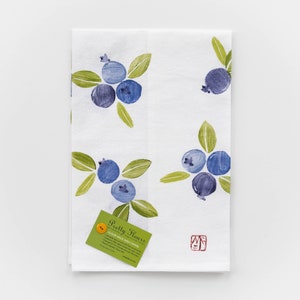 May include: White flour sack dish towel with a blue and green blueberry design. The towel has the text "Pretty Flowers" and a small red stamp.