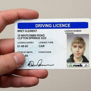May include: A rectangular plastic driving licence card with a blue header reading DRIVING LICENCE. It displays the name BRET CLEMENT, address 15 WHITCOMBS ROAD CLIFTON SPRINGS 3222, licence number 52004256, expiry 01-05-09, type CAR, and a portrait photo.