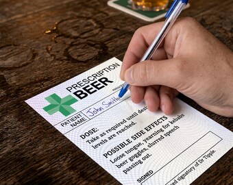Può includere: Un ricettario rettangolare bianco con una croce verde e il testo Prescription Beer. Il modulo include campi per il nome del paziente, la dose e i possibili effetti collaterali, con il nome John Smith scritto in inchiostro blu con una penna.