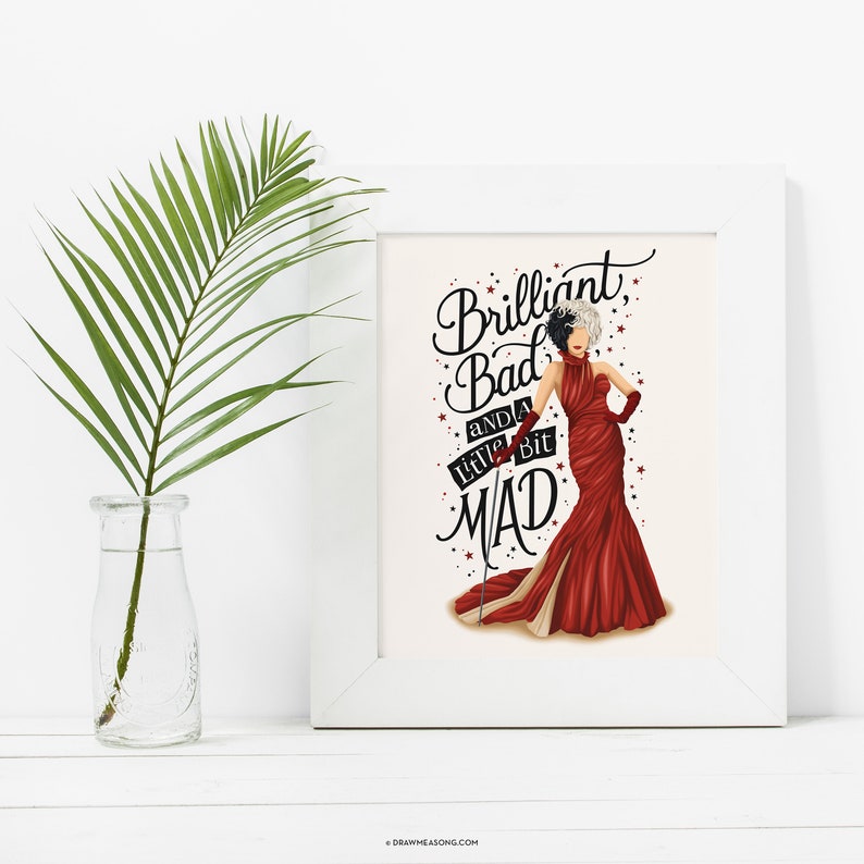 May include: A white framed print with a black and white illustration of a woman in a red dress. The text on the print reads "Brilliant, Bad and a little bit MAD".