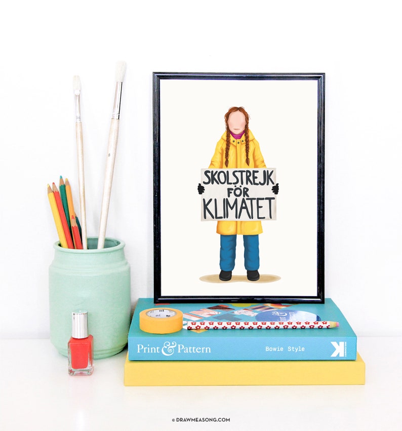 Puede incluir: Una ilustraci&oacute;n enmarcada de una persona con un impermeable amarillo sosteniendo un cartel que dice "SKOLSTREJK FOR KLIMATET". La ilustraci&oacute;n est&aacute; sobre un fondo blanco. El marco es negro.