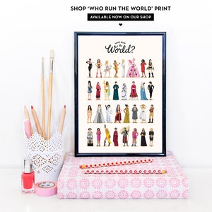 Puede incluir: Una impresi&oacute;n enmarcada en negro con el texto "WHO RUN the World?" y una ilustraci&oacute;n colorida de 24 mujeres. La impresi&oacute;n est&aacute; sobre una superficie con estampado rosa y blanco.