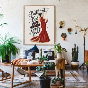 May include: A framed print with a white background and a black and white illustration of a woman in a red dress. The text "Brilliant, Bad and a little bit MAD" is written in black cursive lettering.