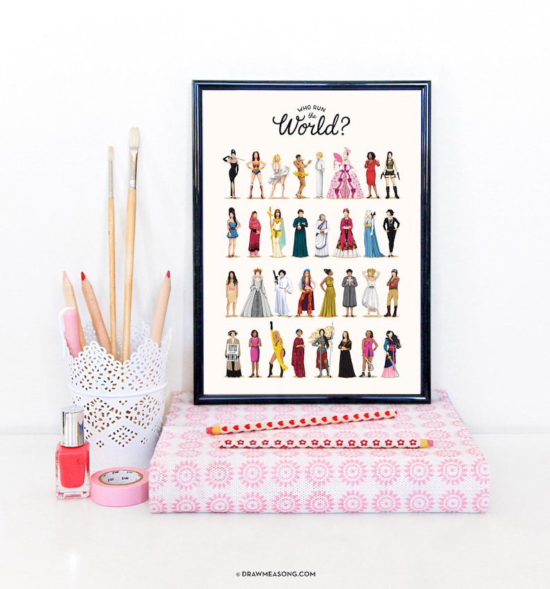 May include: A black framed print with a white background featuring a colorful illustration of women from different cultures and backgrounds. The text "Who Run the World?" is written in black cursive at the top of the print.