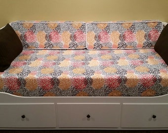 May include: White daybed with three drawers and a floral patterned mattress and pillows. The pillows are brown.