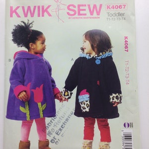 May include: A sewing pattern for a toddler's coat. The pattern is called "Kwik Sew" and the number is K4067. The pattern is for sizes T1-T2-T3-T4. The pattern shows two girls wearing the coat, one in purple and one in black.