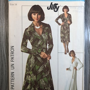 May include: Simplicity sewing pattern number 7705 for a Jiffy wrap dress. The pattern includes instructions for making a long-sleeved wrap dress with a V-neckline. The pattern is for size 14.