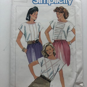 Puede incluir: Patrón de costura Simplicity número 6808 para una blusa de mujer. El patrón muestra tres estilos diferentes de blusas con mangas cortas y costuras decorativas. El patrón es para la talla 14.