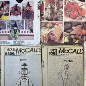 May include: Four McCall's Crafts sewing patterns. The top left pattern is for Halloween decorations, the top right pattern is for holiday table decorations, the bottom left pattern is for a Bert the Monster plush toy, and the bottom right pattern is for a Grover the Monster plush toy.