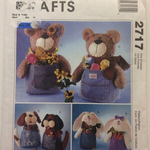 May include: A sewing pattern for making stuffed animal toy containers. The pattern includes instructions for making a bear, a bunny, and a dog. The toys are all wearing overalls and have pockets. The pattern is called "McCall's AFTs 2717".