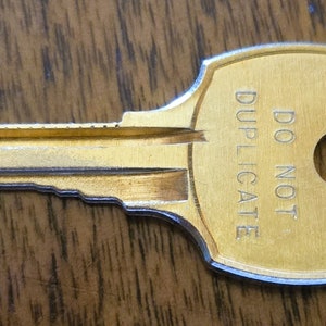 May include: A gold-colored key with a round hole and the words "DO NOT DUPLICATE" engraved on the head.