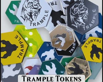 May include: A collection of hexagonal tokens in various colors and finishes, featuring a bull illustration or a footprint graphic with the text TRAMPLE. The image includes a label with the text TRAMPLE TOKENS 2 Different Options / 2 Sizes.