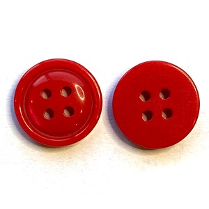May include: Two red plastic buttons with four holes each. The buttons are round and have a smooth surface.