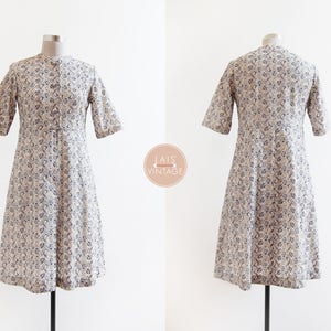 May include: A white dress with a floral pattern and short sleeves. The dress has a button-up front and a slightly flared skirt.