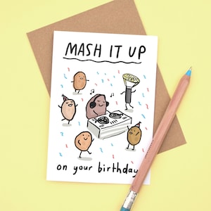 May include: A white card with a cartoon illustration of potatoes dancing and a potato DJ. The card says "Mash it up on your birthday".