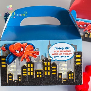 Puede incluir: Caja de regalo azul y roja con un dise&ntilde;o de personaje de Spiderman. La caja tiene un asa y dice "Gracias por celebrar conmigo hoy, Con cari&ntilde;o, Anthony".