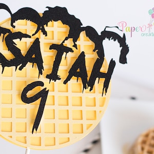 May include: A yellow waffle-shaped cake topper with black lettering that says "ISAIAH 9".