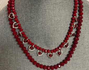 A 2 stranded necklace of red crystal beads, with silver hearts