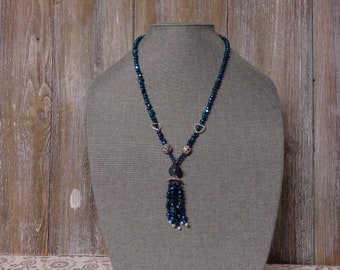 A blue crystal necklace with a crystal tassel