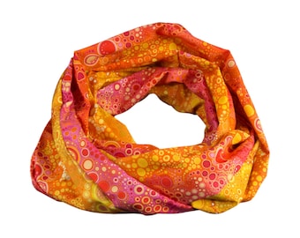 May include: A colorful infinity scarf with a pattern of pink, orange, and yellow circles.