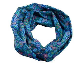May include: A blue infinity scarf with a colorful pattern of circles and flowers.