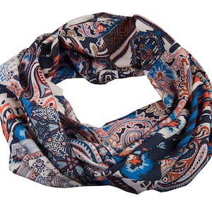 Könnte beinhalten: Ein farbenfroher Schal mit Paisley-Muster in Blautönen, Rot und Braun. Der Schal ist zu einem Kreis gefaltet und bereit zum Tragen.