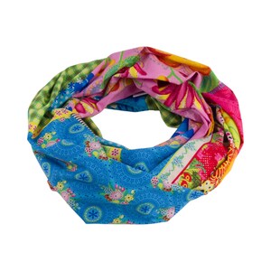 Könnte beinhalten: Ein farbenfroher Loop-Schal mit Patchwork-Design. Der Schal zeigt eine Vielzahl von Mustern, darunter Blumen-, Paisley- und geometrische Drucke in Blau, Rosa, Grün und Gelb. Der Schal ist aus einem weichen, leichten Stoff gefertigt.